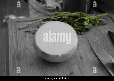 Preparazioni alimentari, tagliere in legno con coltello alle erbe fresche sull'isola della cucina. Foto Stock