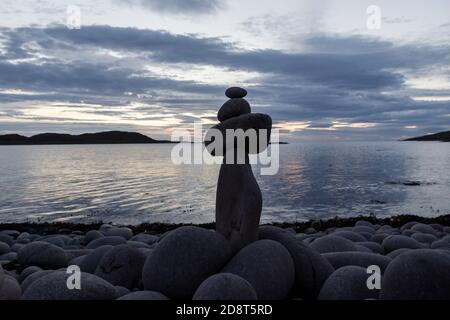 Pietre impilate in equilibrio su una riva rocciosa, Regno Unito Foto Stock