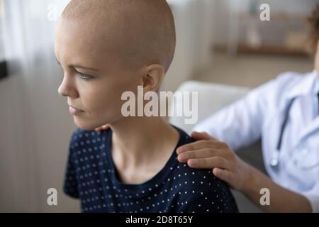 Primo piano medico di sostegno infelice donna senza capelli che lotta con il cancro Foto Stock