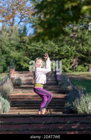 Donna bionda, quaranta anni pratica yoga pone in un ambiente esterno, Londra, Inghilterra Foto Stock
