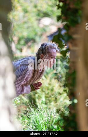 Donna bionda, quaranta anni pratica yoga pone in un ambiente esterno, Londra, Inghilterra Foto Stock
