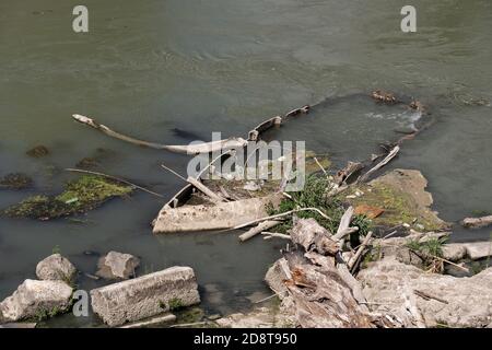 Naufragio in barca sul fiume Tevere a Roma, in Italia, sommerso e parzialmente coperto d'acqua Foto Stock