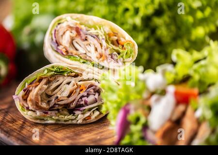 Tortilla avvolge con carne, verdure, maionese con un'insalata sul lato Foto Stock
