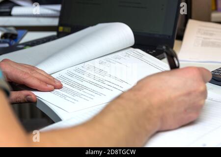 Lo studente risolve le formule matematiche. L'uomo scrive con una penna in un notebook. Compiti. Note in un notebook. Foto Stock