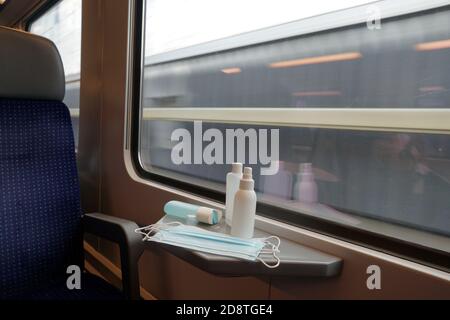 Nuovo concetto normale per i pendolari e i viaggi in treno. Maschere facciali e disinfettanti per le mani sono attrezzature obbligatorie per pendolari e viaggiatori. Foto Stock