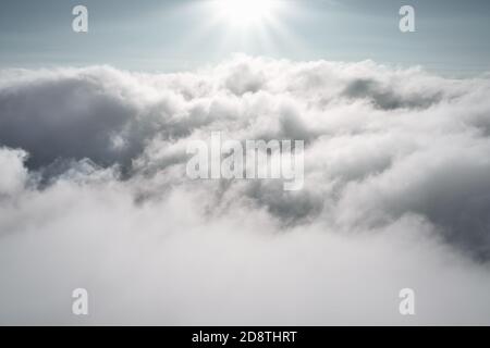 Nuvole nel cielo con il sole che splende. Fotografia aerea all'aperto, vista mentre parapendio sopra le nuvole. Foto Stock