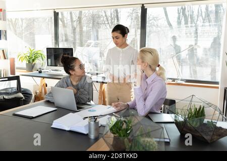 Giovane e fiduciosa etnia indiana, leader del team femminile, coaching colleghi. Foto Stock