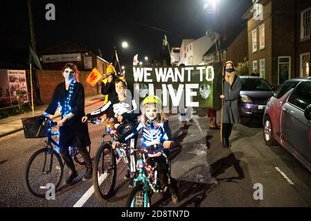 Hastings, Regno Unito. 31 ottobre 2020. Estinzione ribellione Halloween protesta e marcia. La vivace marcia lasciò la città vecchia una volta buia, e includeva potenti batteristi di samba, scheletri, biciclette illuminate, un mondo di effigie da fuoco, torce da fuoco e terminò con bombe di fumo. Le strade sono state bloccate da 10M banner per consentire alla marcia di attraversare le strade in modo sicuro. La protesta ha richiesto un'azione immediata e significativa da parte del governo per affrontare le sfide di un'emergenza climatica. Ospitato da Extinction Rebellion Hastings / St Leonards e Extinction Rebellion South-East UK. Credito: Stephen Bell/Alamy Foto Stock