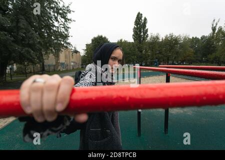 Ragazza teenager problemi di socializzazione nuvoloso giorno d'autunno. Bella ragazza guarda direttamente nella macchina fotografica, foto di strada, primo piano Foto Stock