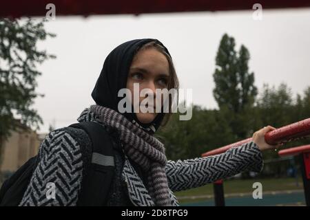 Ragazza teenager problemi di socializzazione nuvoloso giorno d'autunno. Bella ragazza guarda direttamente nella macchina fotografica, foto di strada, primo piano Foto Stock