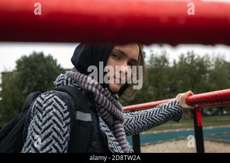 Ragazza teenager problemi di socializzazione nuvoloso giorno d'autunno. Bella ragazza guarda direttamente nella macchina fotografica, foto di strada, primo piano Foto Stock