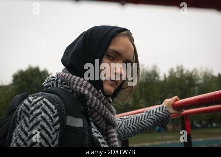 Ragazza teenager problemi di socializzazione nuvoloso giorno d'autunno. Bella ragazza guarda direttamente nella macchina fotografica, foto di strada, primo piano Foto Stock