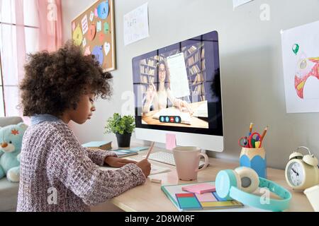 Scuola africana ragazzina imparare a distanza con insegnante online a casa. Foto Stock