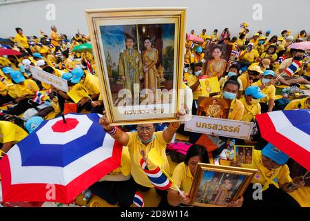 I sostenitori del re tailandese Maha Vajiralongkorn e della regina Suthida si riuniscono prima della cerimonia religiosa, fuori dal Grand Palace di Bangkok. Le persone vestite di giallo si sono recate al Sanam Luang di Bangkok e al Tempio del Buddha di Smeraldo per dimostrare la loro lealtà a sua Maestà il Re. Foto Stock