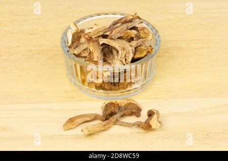 Funghi porcini secchi in un ramekin di vetro su un legno tagliere Foto Stock