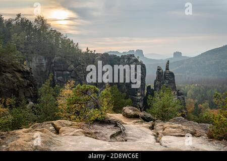 Montagne di pietra arenaria dell'Elba - Vista con le formazioni rocciose prominenti e ampio paesaggio nella luce posteriore, luce della sera con le nuvole chiare e un po' di foschia, dentro Foto Stock