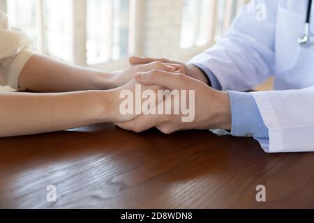 Medico che tiene le mani del paziente con cura incoraggiando a prendere il trattamento Foto Stock