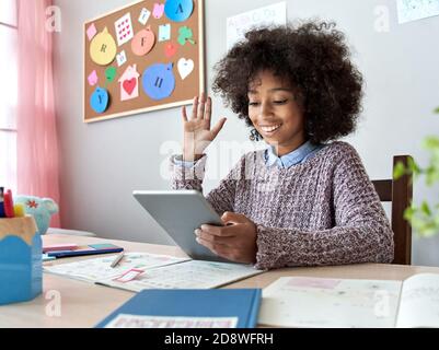 Ragazza capretto africana che svela la mano videochiama l'apprendimento a distanza su tablet digitale. Foto Stock