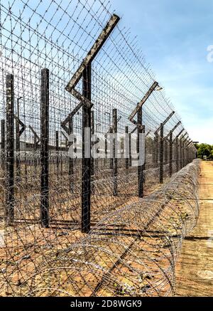 La recinzione di protezione sicura di bordo di Barbwire è elettrificata della prigione. Foto Stock