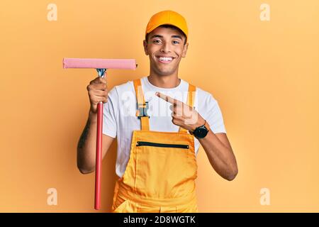 Giovane bell'afroamericano uomo detergente per vetri che tiene la rondella di vetro sorridente, con mano e dito Foto Stock