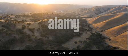 La luce del sole di sera splende sulle colline ondulate della California settentrionale. Queste splendide colline dorate diventano verdi una volta che l'inverno porta piogge stagionali. Foto Stock