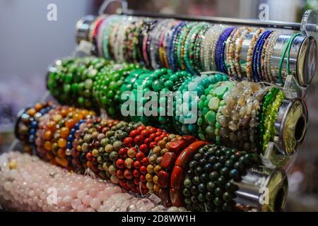 Gemma bracciali e collane in una fila. La bigiotteria fatta di agata blu cristallo di quarzo di montagna, Rosso corallo pietre occhio di tigre pietre. La guarigione, potente Foto Stock