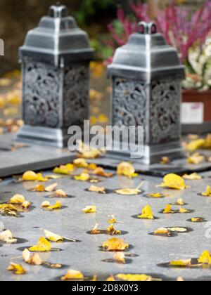 Lanterne su pietra tombale di granito. Cimitero della città vecchia nel parco forestale. 24 ottobre 2020. Hronov, Repubblica Ceca. Foto Stock