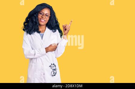 Bella donna opticista afroamericana con occhiali da ottometria sorridente felice puntare con la mano e il dito verso il lato Foto Stock