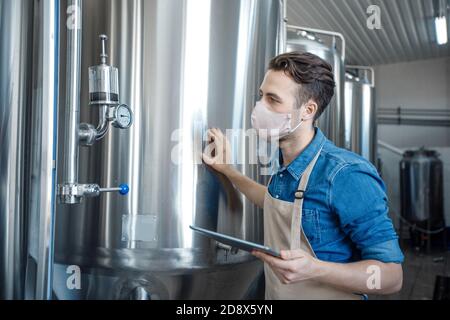 Lavorare in una moderna fabbrica di birra all'epidemia di covid-19 Foto Stock