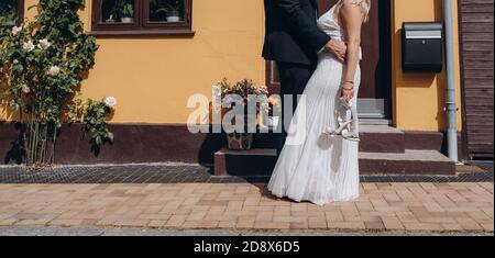 Coppia nuziale che tiene le mani e cammina insieme, sposa felice e sposo. Foto Stock