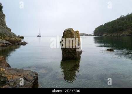 Due barche ancorate su entrambi i lati di una roccia a Watmough Bay sull'Isola di Lopez, Washington, USA Foto Stock