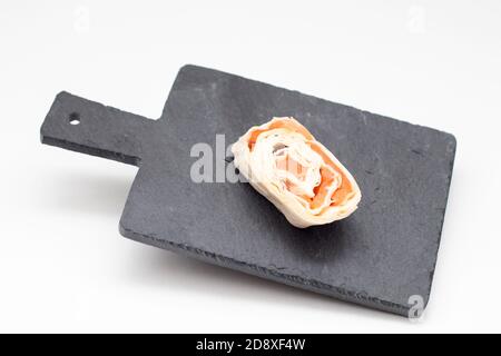 Pancakes rotolo di salmone su tavola di ardesia nera livitante per snack Foto Stock