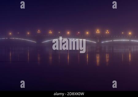 Paesaggio notturno foggoso con Trinity Bridge con lanterne splendenti (San Pietroburgo, Russia) Foto Stock