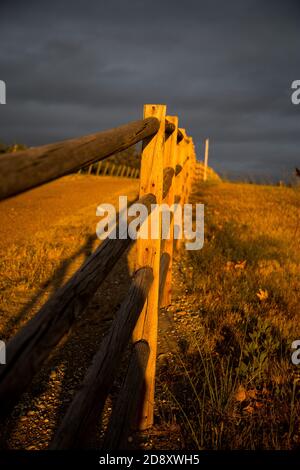 Spettacolare vista lineare del ranch rustico recintato lungo Orcutt Road San Luis Obispo County, California al tramonto mentre una tempesta si avvolna Foto Stock