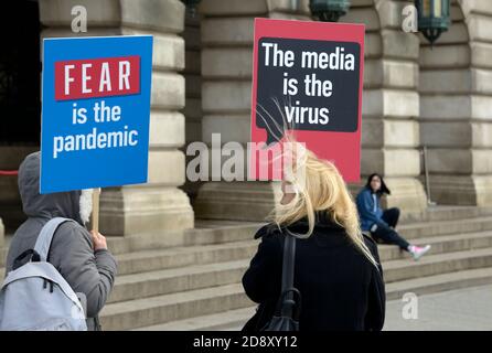 La gente alla riunione di teoria di cospirazione con i cartelli Foto Stock