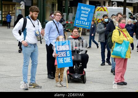 La gente alla riunione di teoria di cospirazione con i cartelli Foto Stock