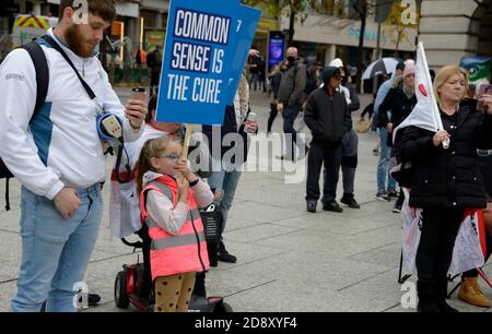 La gente alla riunione di teoria di cospirazione con i cartelli Foto Stock