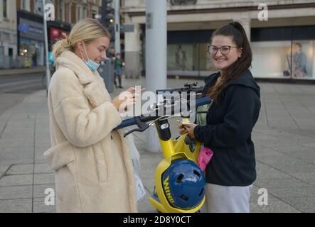 Giovani donne che provano gli scooter elettrici. Foto Stock