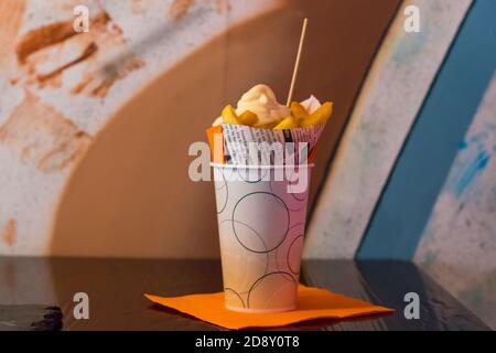 Deliziose patatine fritte, patate fritte fatte in casa al forno con patatine di salsa fresca su sfondo di legno Foto Stock