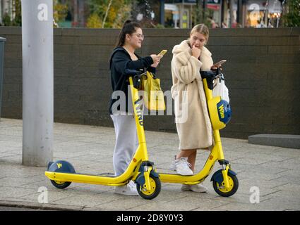 Giovani donne che provano gli scooter elettrici. Foto Stock