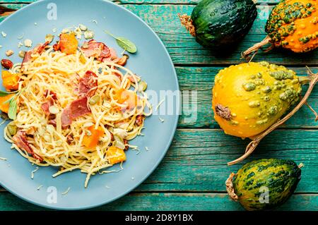 Menu autunnale, pasta con zucca e pancetta. Pasta carbonara. Pasta con zucca al forno Foto Stock