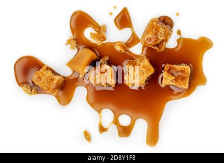 Composizione di caramello fuso con caramelle e salsa isolate su sfondo bianco, vista dall'alto Foto Stock