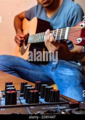 Scatto verticale di un maschio che suona sulla chitarra Foto Stock