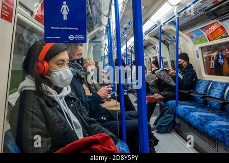 Londra, Regno Unito. 02 novembre 2020. Segnali di avvertimento e consigli sono ovunque - indossare una maschera, mantenere la distanza, essere attenti. I viaggiatori indossano soprattutto maschere, in quanto sono ora obbligatori sui trasporti pubblici. Il numero di passeggeri è aumentato sul tubo proprio come il governo annuncia che un nuovo Coronavirus (covid 19) blocco inizierà il giovedi. Credit: Guy Bell/Alamy Live News Foto Stock