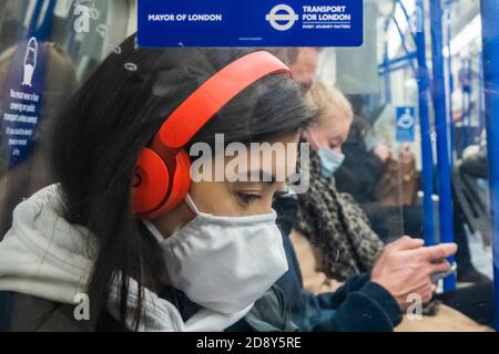 Londra, Regno Unito. 02 novembre 2020. Segnali di avvertimento e consigli sono ovunque - indossare una maschera, mantenere la distanza, essere attenti. I viaggiatori indossano soprattutto maschere, in quanto sono ora obbligatori sui trasporti pubblici. Il numero di passeggeri è aumentato sul tubo proprio come il governo annuncia che un nuovo Coronavirus (covid 19) blocco inizierà il giovedi. Credit: Guy Bell/Alamy Live News Foto Stock