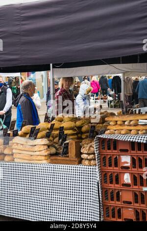 La gente che compra il pane da una bancarella del mercato di sabato nel centro della città di St. Albans, St. Albans, Hertfordshire, Inghilterra, Regno Unito. Foto Stock