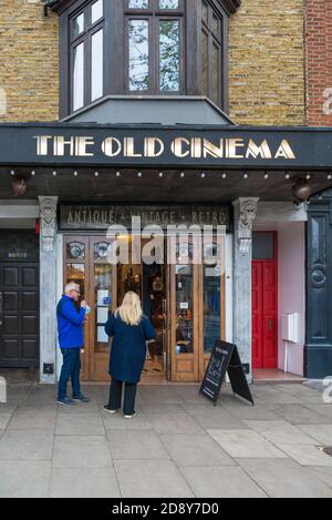 Coppia matura che si trova fuori dal negozio di antiquariato Old Cinema, Chiswick High Road, Londra, Inghilterra, Regno Unito Foto Stock