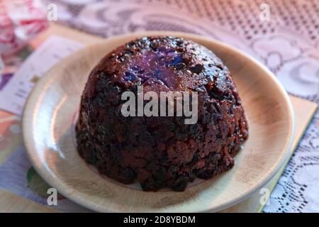 Dessert natalizio illuminato con una fiamma di brandy bruciante servito A cena il giorno di Natale durante la stagione festiva Nel mese di dicembre stock foto im Foto Stock