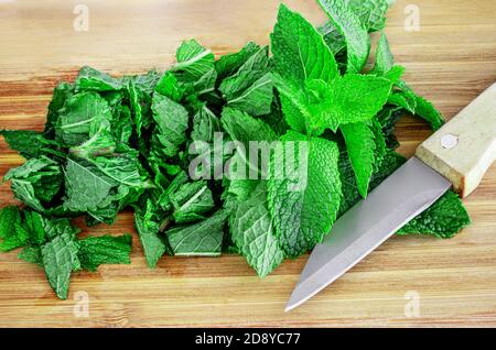 Menta fresca su tavolo di legno, spazio copia. Foglie di menta verde tagliate Vista dall'alto Foto Stock