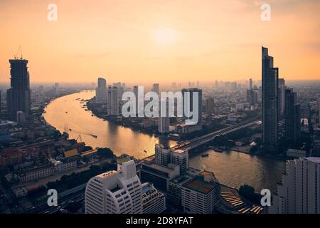 Skyline urbano Bangkok al tramonto. Grattacieli vicino al fiume Chao Phraya, Thailandia. Foto Stock